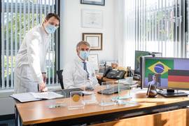 (UKM/Wibberg): Die Neurochirurgen Dr. Murat Yavuz (l.) und Prof. Walter Stummer (r.) wollen Behandlungsstandards ihrer Diziplin nach Curitiba transferieren.
