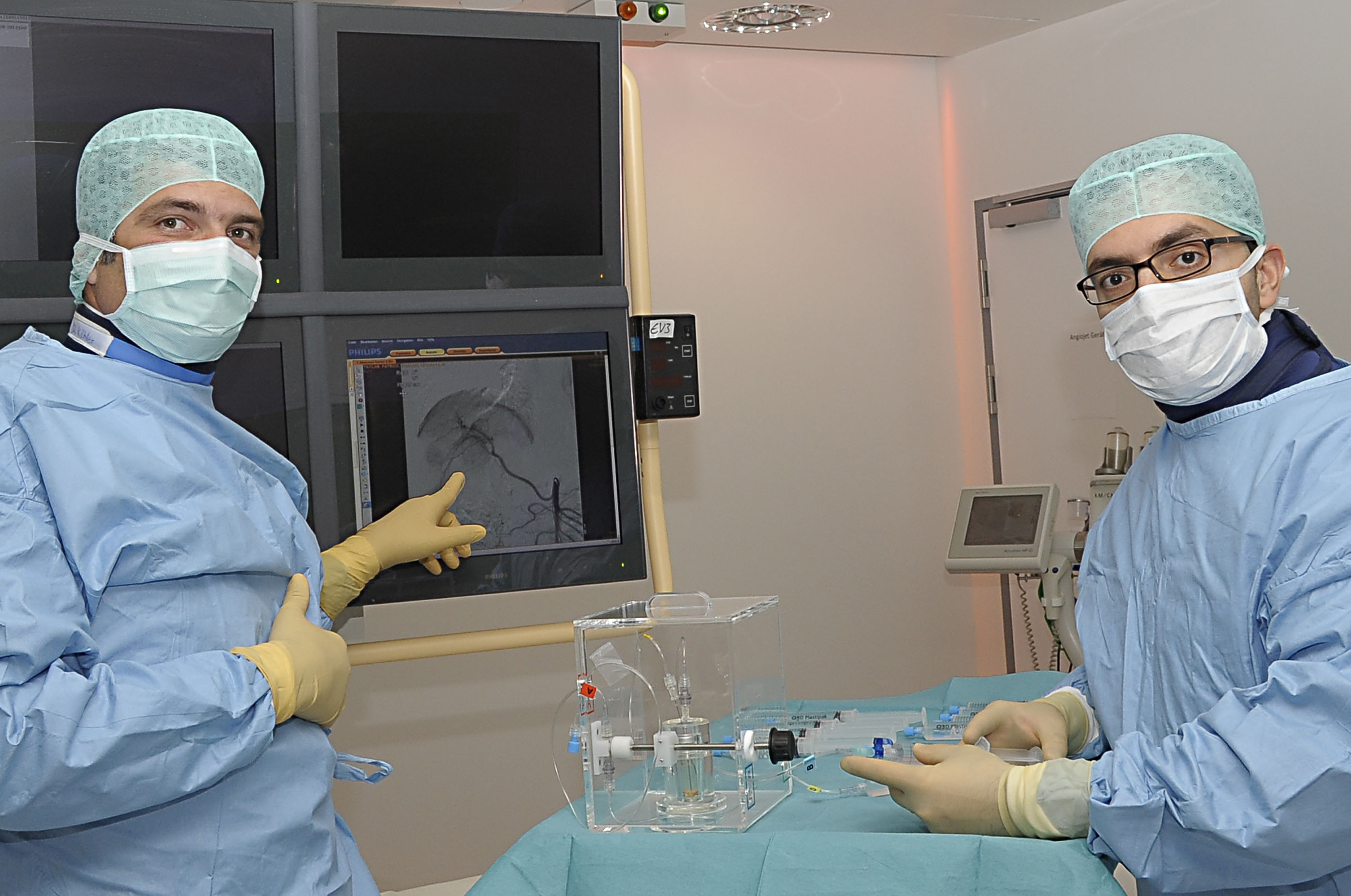 Die Mediziner verfolgen auf einem Bildschirm den Weg der strahlenden Mikrokügelchen zum Tumor in der Leber.